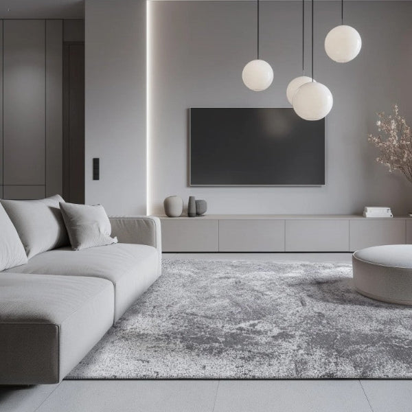 Modern living room with gray sofa, rug, and pendant lights.