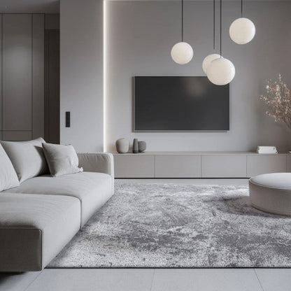 Modern living room with gray sofa, rug, and pendant lights.