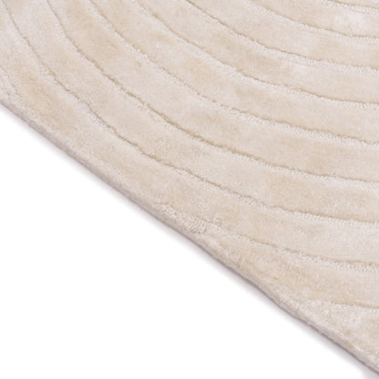 Close-up of a textured beige rug corner on a white background