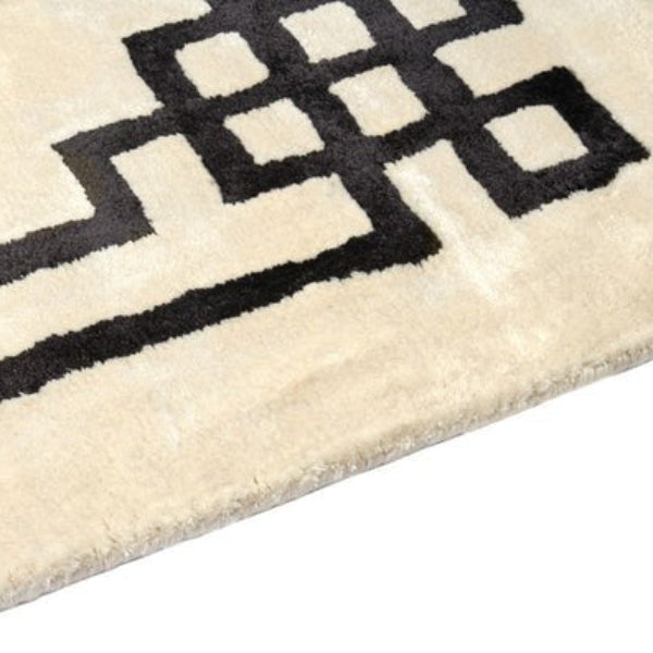 Close-up of a beige rug with black geometric pattern