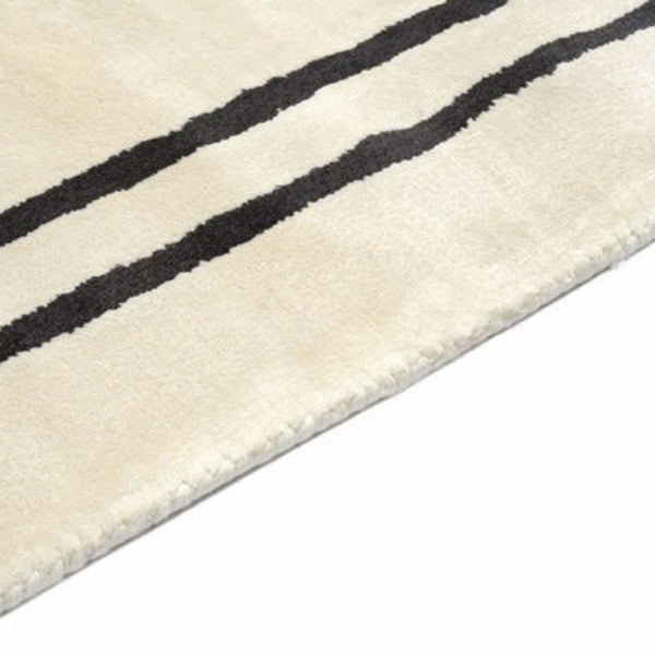 Close-up of a beige rug with black stripes on a white background