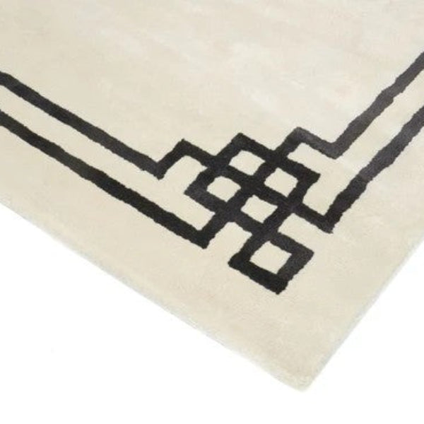 Close-up of a beige rug with black geometric patterns