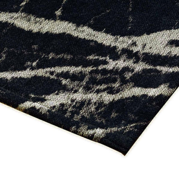 Textured black and white patterned rug corner on a white background