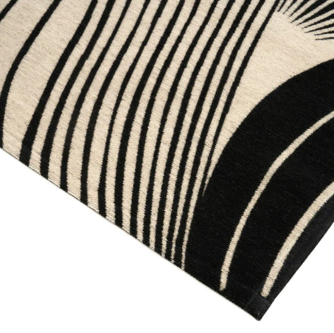 Close-up of a black and beige patterned rug on a white background