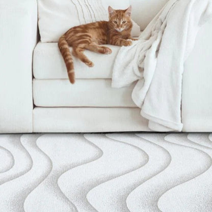 Cat lying on a white sofa with a white textured rug in the foreground