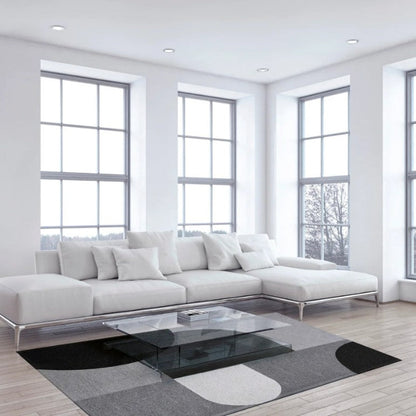 Modern living room with a white sofa, glass coffee table, and large windows.