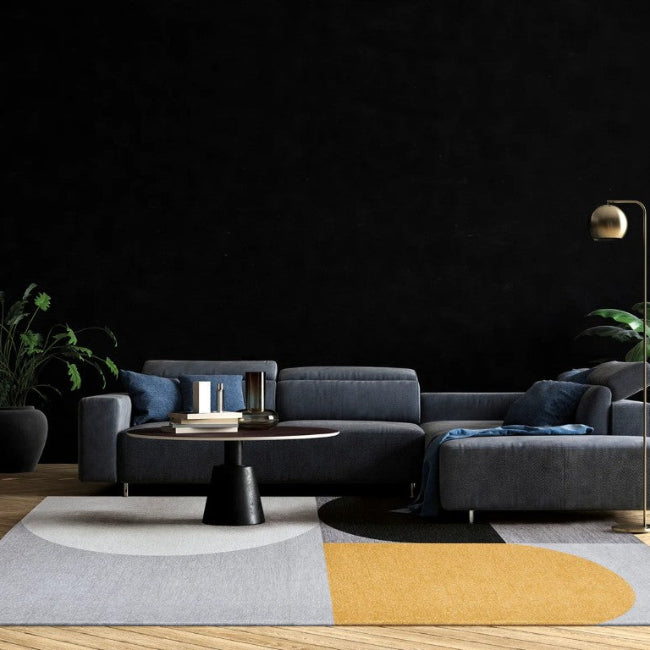 Modern living room with a gray sofa, round coffee table, and decorative elements on a dark background.