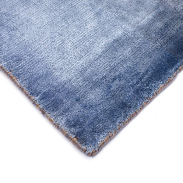 Close-up of a blue denim fabric corner on a white background