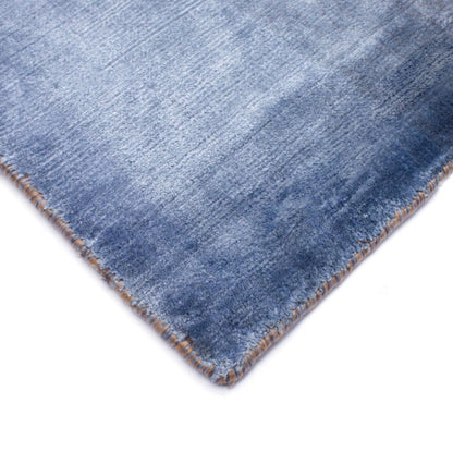 Close-up of a blue denim fabric corner on a white background