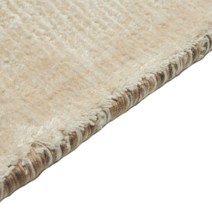 Close-up of a beige rug with a textured border on a white background