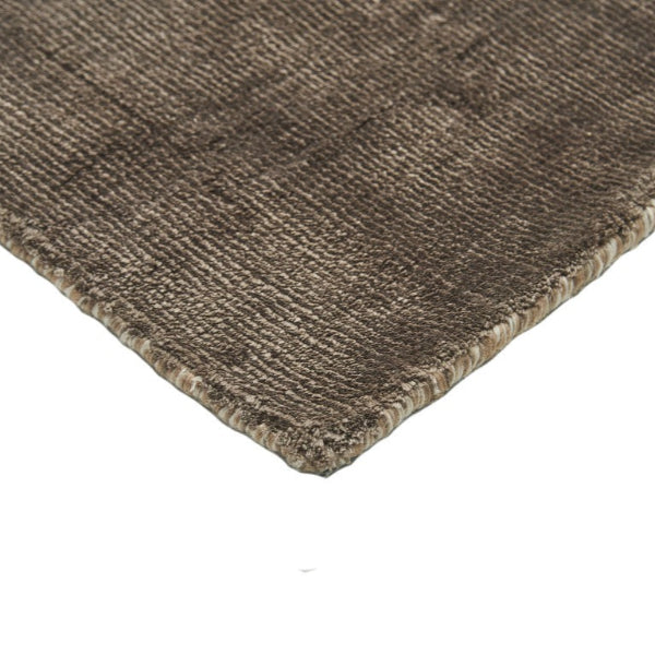Close-up of a brown textured rug corner on a white background