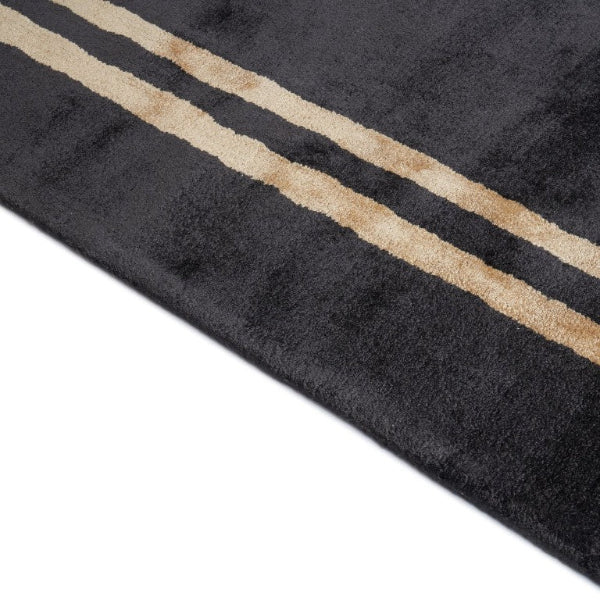 Black rug with gold stripes on a white background