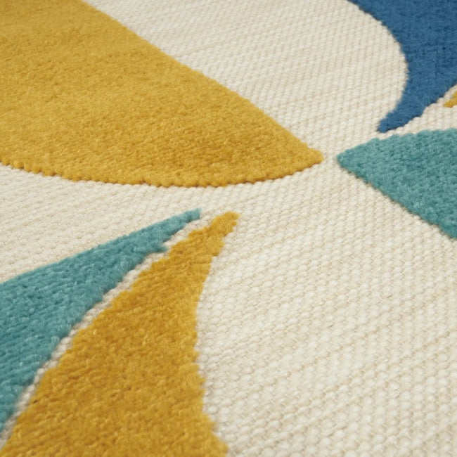Close-up of a textured rug with geometric pattern in blue, yellow, and beige.