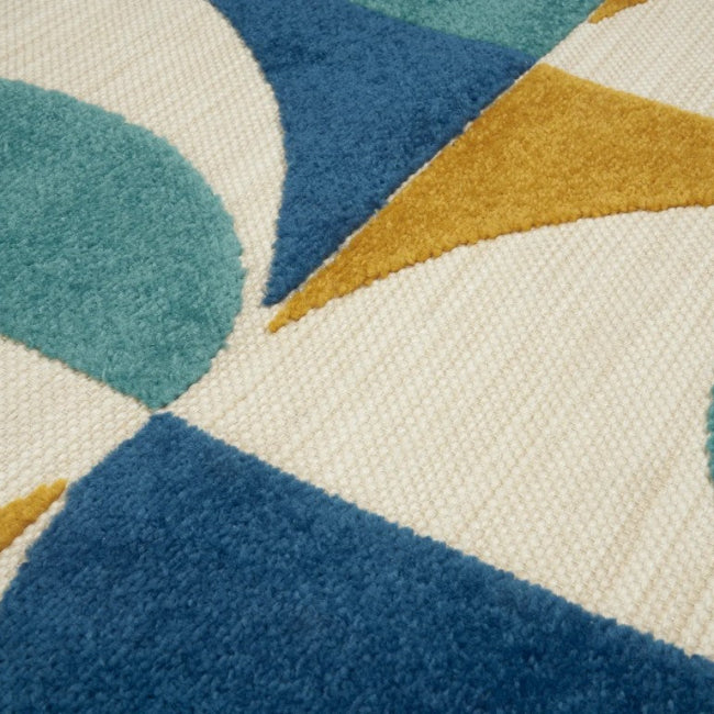 Close-up of a geometric patterned rug with blue, green, and gold colors on a white background.