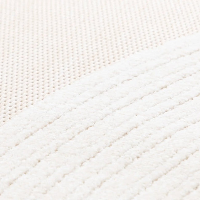 Close-up of a textured white fabric with diagonal stitching pattern