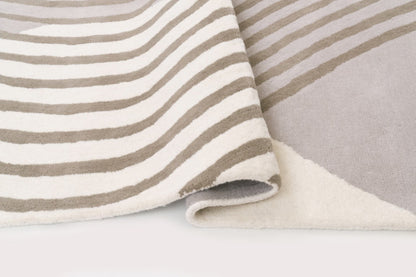 Close-up of striped fabric with beige and white stripes on a light gray background