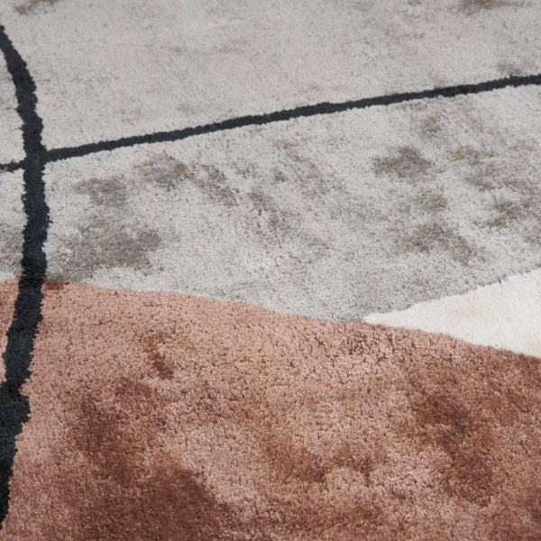 Luxury rug by Carpet Décor featuring geometric patterns in grey, black, and earthy tones