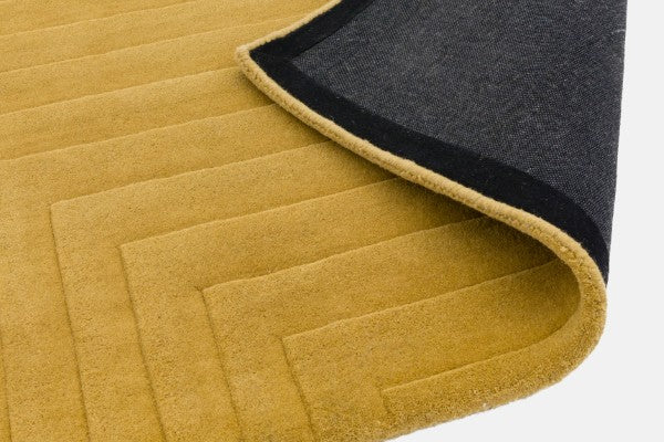 Asiatic Contemporary Plains Rug luxury mustard yellow flatwoven design with folded corner showing backing
