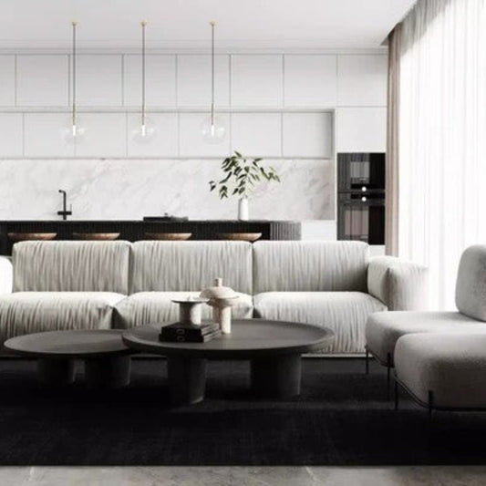 Modern living room with a gray sectional sofa and round coffee table.