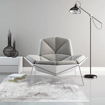 Modern gray armchair with geometric design in a minimalistic room.