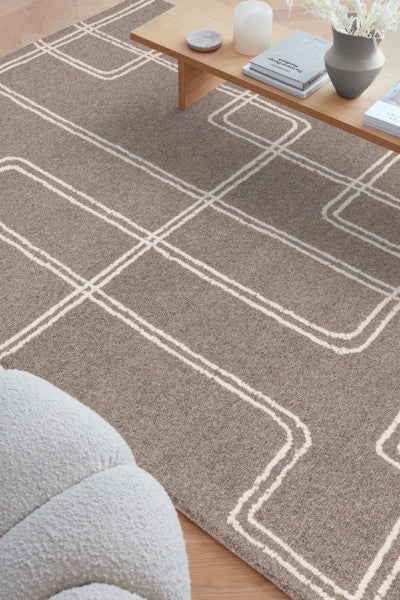 Asiatic Boho Collection Ada Rug in neutral tones with geometric white line patterns in modern living room