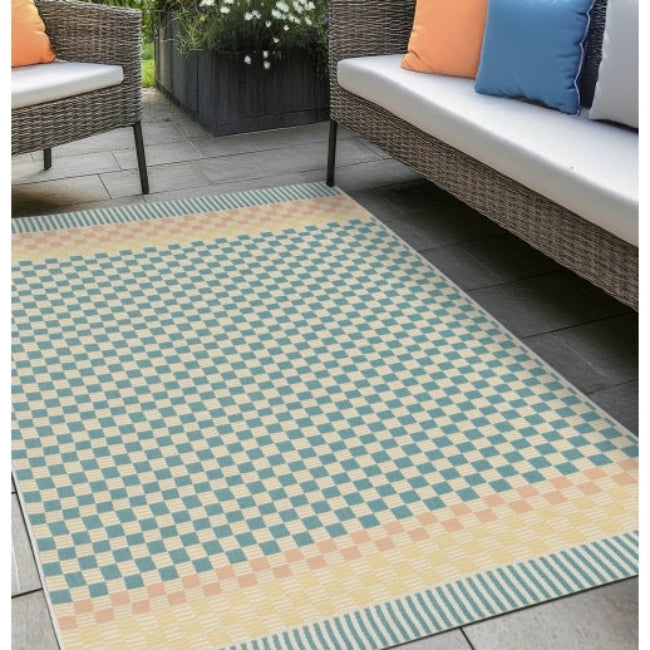Cosmos Chequer Pastel Outdoor Rug on patio with wicker furniture and colourful cushions