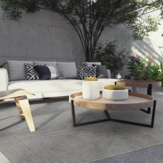 Outdoor patio setting with modern furniture including a sofa, chairs, and coffee table.