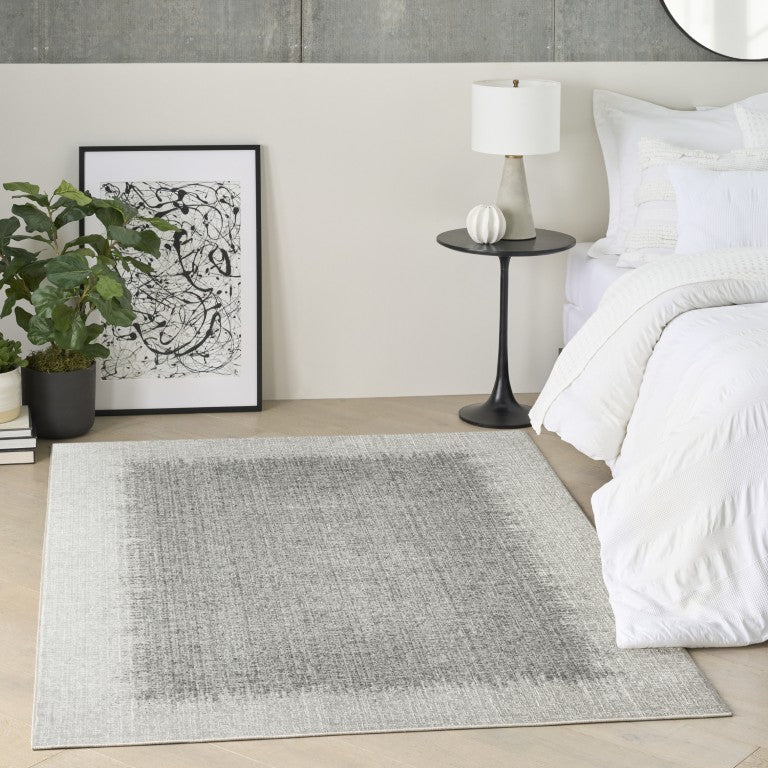 The DKNY Grand Street Rug Collection in grey complements modern bedroom decor with its elegant design
