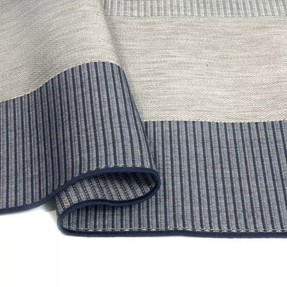 Close-up of a gray and blue striped rug with textured pattern