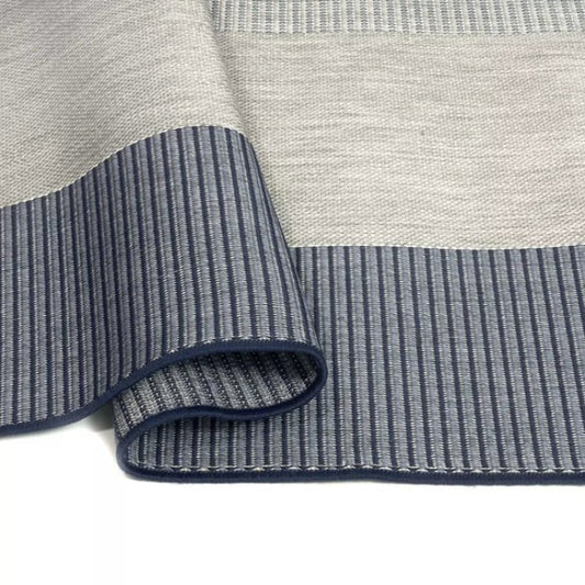 Close-up of a gray and blue striped rug with textured pattern