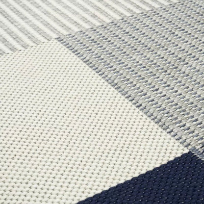 Close-up of a textured fabric with geometric pattern in blue and gray.