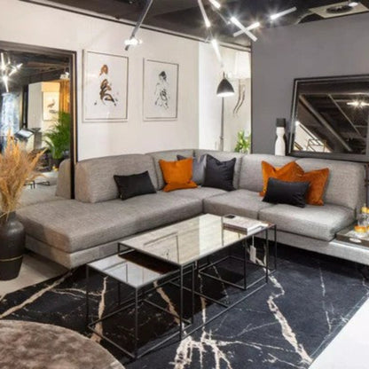 Modern living room with a gray sectional sofa, decorative pillows, and a coffee table.