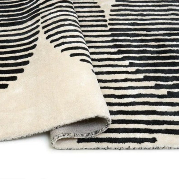Close-up of a black and white striped rug with a folded corner.