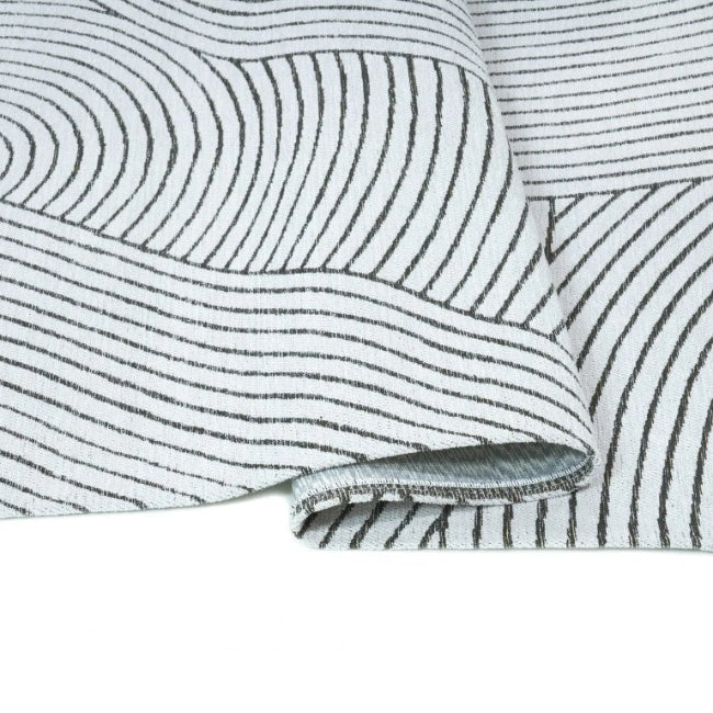 Close-up of a textured fabric with wavy lines on a white background