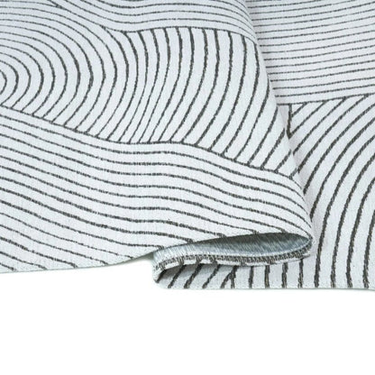 Close-up of a textured fabric with wavy lines on a white background