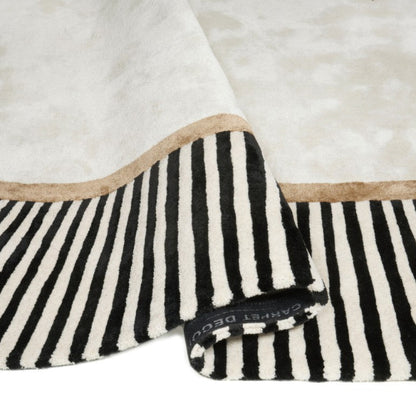 Folded black and white striped blanket with beige border on a white background