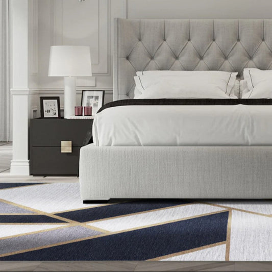 Modern bedroom with a gray upholstered bed and decorative elements.