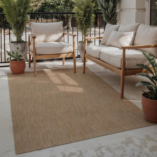 Outdoor patio with wooden furniture, cushions, and potted plants on a beige rug.