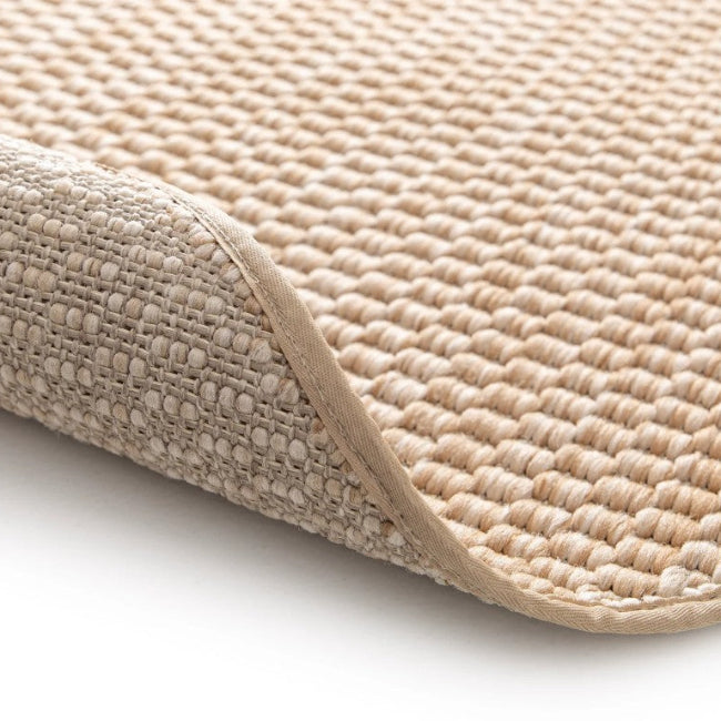 Beige textured bath mat on a white background
