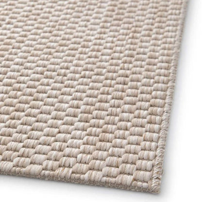 Close-up of a textured beige rug on a white background