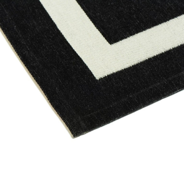 Close-up of a black and white geometric patterned rug corner.