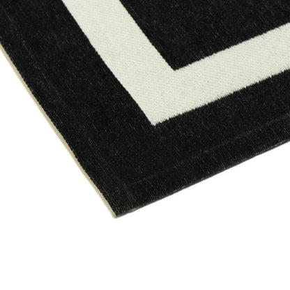 Close-up of a black and white geometric patterned rug corner.