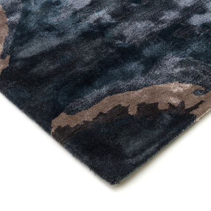 Close-up of a dark blue and brown patterned rug corner on a white background