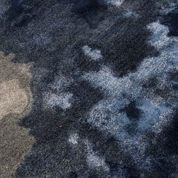 Close-up of a textured rug with a camouflage pattern in shades of blue, grey, and beige.