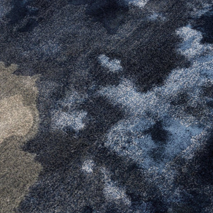 Close-up of a textured rug with a camouflage pattern in shades of blue, grey, and beige.