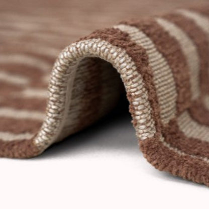 Close-up of a soft brown and beige striped Louis De Poortere Berber Rug edge showing detailed weaving