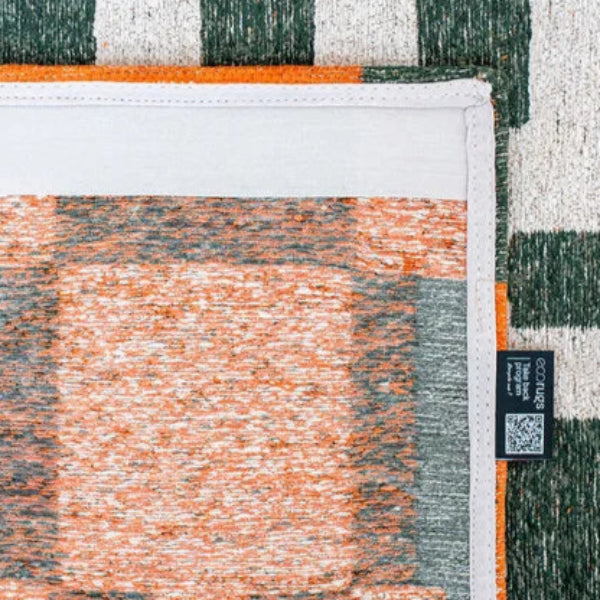 Close-up of Louis De Poortere Chess rug showing detailed stitching and textured woven pattern in orange and green