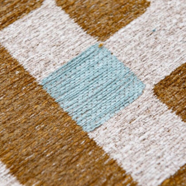 Close-up of luxury Louis De Poortere Chess rug featuring textured blue, white, and brown squares in checkerboard pattern