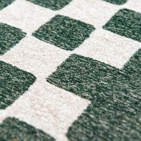 Close-up of Louis De Poortere Chess rug showing green and cream textured squares in luxury design