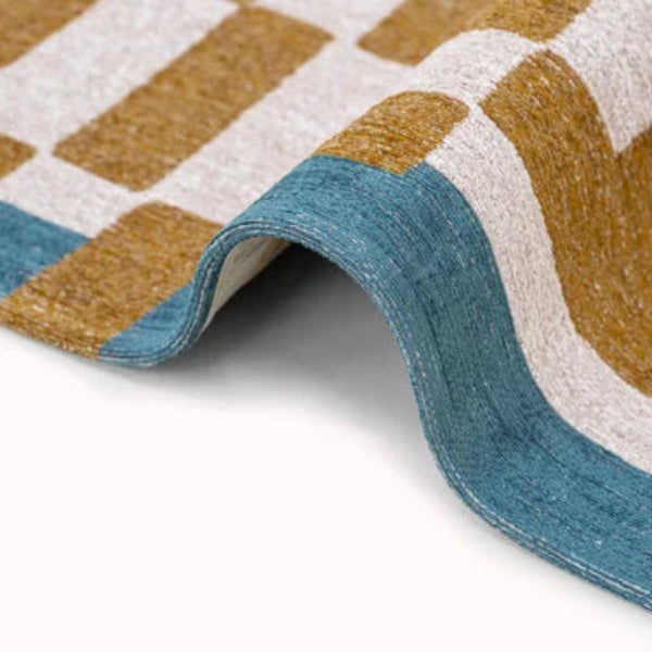 Close-up view of luxury Louis De Poortere Chess rug with blue, brown, and white geometric pattern